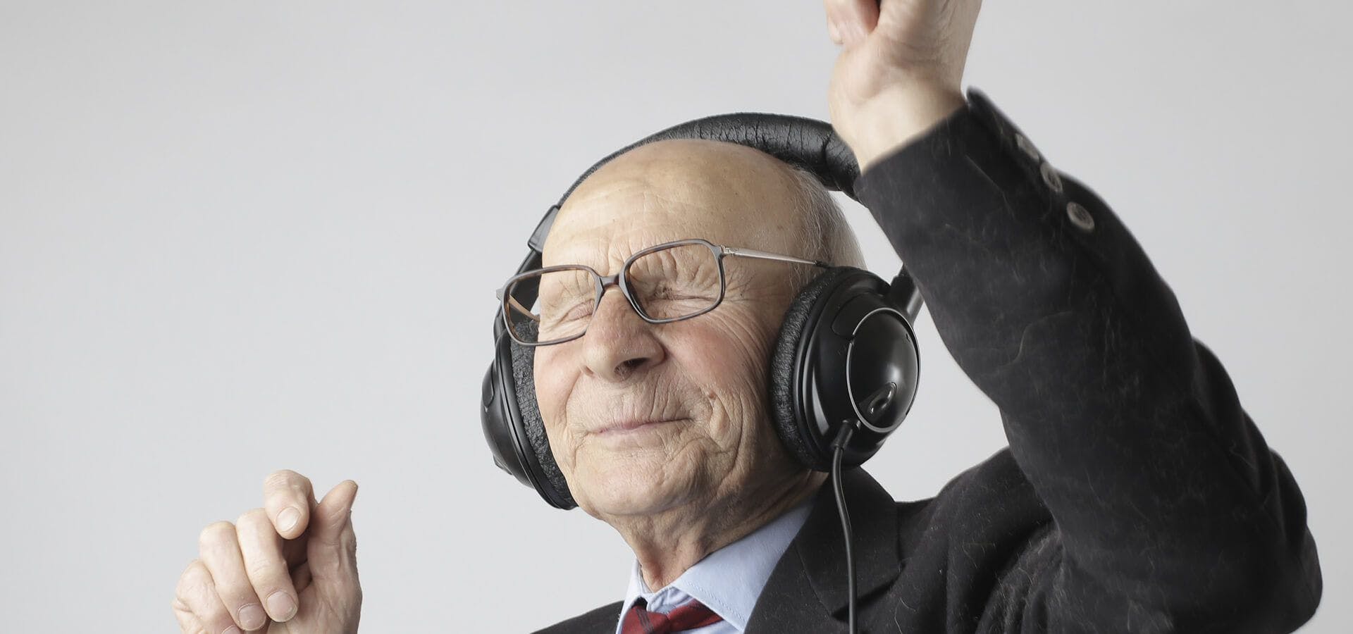 Señor mayor escuchando música y bailando con cascos