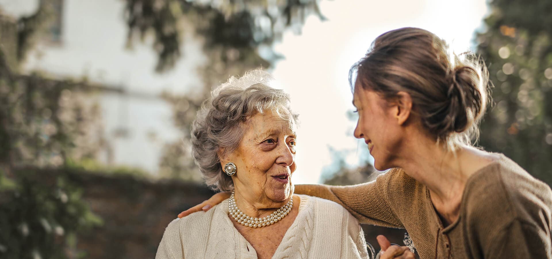 Señora mayor en un parque con su cuidadora