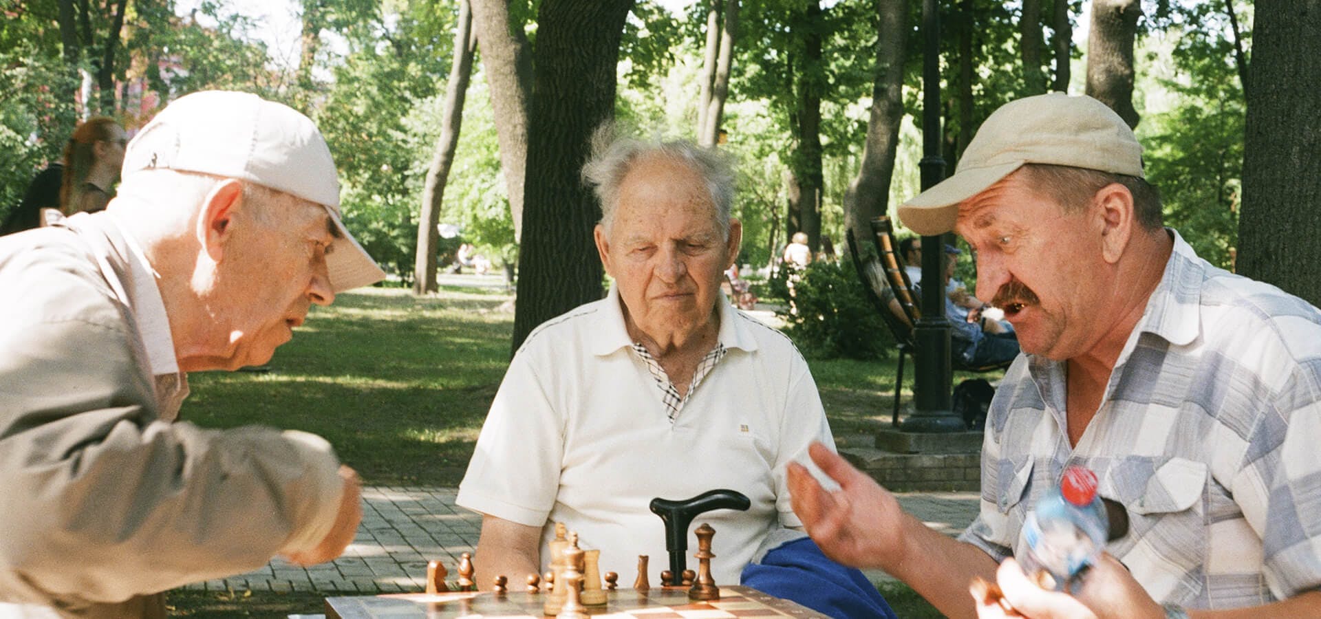 Tres señores mayores jugando al ajedrez en un parque