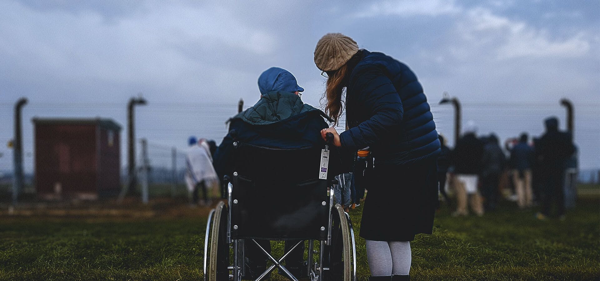Persona cuidando a una mayor en silla de ruedas